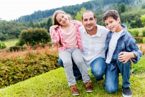 dad 2 kids on grassy hill